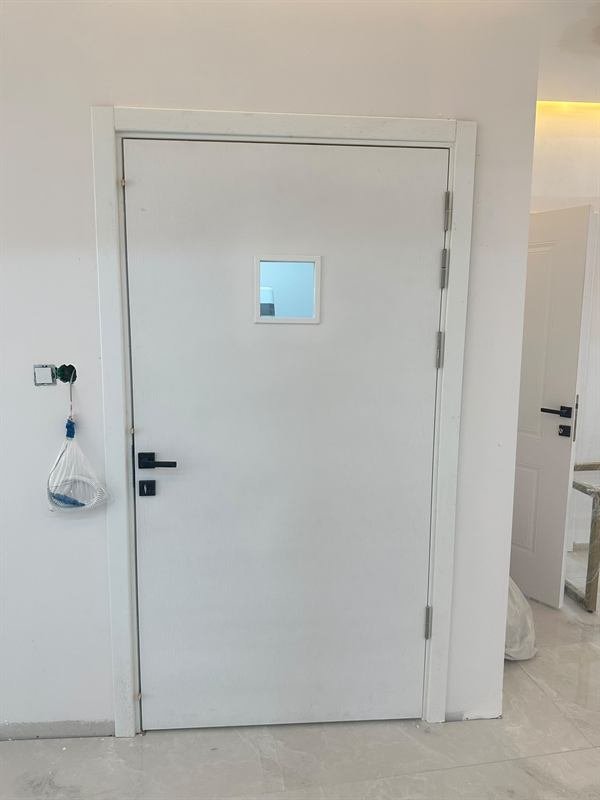 Klinik girişinde beyaz kurşunlu kapı — RadEX Kurşun